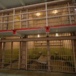Prison cell block with barred doors and two tiers