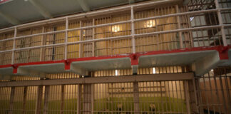 Prison cell block with barred doors and two tiers
