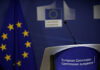 European Commission podium and flag background.