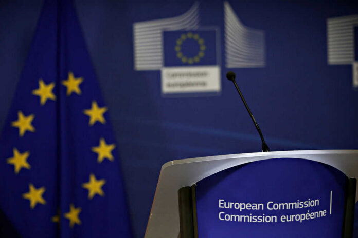 European Commission podium and flag background.