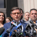 Group of people speaking at a press conference.