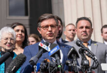 Group of people speaking at a press conference.