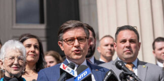 Group of people speaking at a press conference.