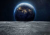 Earth rising above the moon’s barren surface in deep space