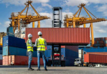 Two workers in safety gear at shipping port