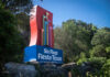 Colorful sign for Six Flags Fiesta Texas surrounded by greenery