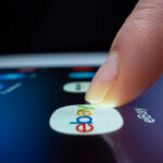 A finger tapping the eBay app icon on a smartphone screen