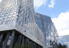 View of modern skyscrapers with reflective glass facades against a blue sky