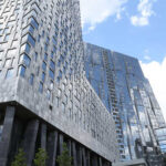 View of modern skyscrapers with reflective glass facades against a blue sky