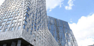 View of modern skyscrapers with reflective glass facades against a blue sky