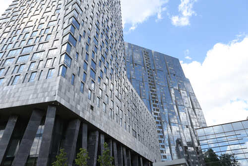 View of modern skyscrapers with reflective glass facades against a blue sky