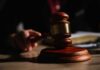 First-Ever Slavery Case SHOCKS Australia – Major Fallout A wooden gavel resting on a table with a blurred hand in the background