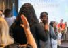 Fraud Allegations Spark DOJ’s Citizenship Hunt Participants raising their hands during a citizenship oath ceremony
