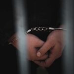 Filipino Sailor CAUGHT With 500 Pounds of Cocaine Close-up of handcuffed hands behind bars
