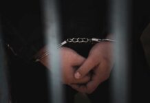 Filipino Sailor CAUGHT With 500 Pounds of Cocaine Close-up of handcuffed hands behind bars