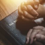 Beijing’s Religious Purge: Zion Church Targeted Two hands clasped in prayer over a Holy Bible
