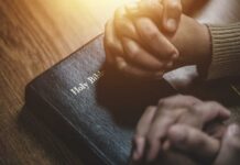 Beijing’s Religious Purge: Zion Church Targeted Two hands clasped in prayer over a Holy Bible