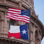 American and Texas flags flying in front of a government building