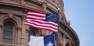 American and Texas flags flying in front of a government building