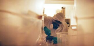 Scientist in protective gear mixing substance in a lab