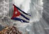 Worn Cuban flag standing on rubble in a desolate urban environment