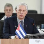 Are US Sanctions Fueling Cuban ‘Bloodbath’ Hysteria? Cuban representative at a political meeting with a flag on the table