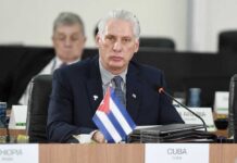 Are US Sanctions Fueling Cuban ‘Bloodbath’ Hysteria? Cuban representative at a political meeting with a flag on the table