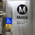 Metro sign with accessibility symbols and bilingual welcome message