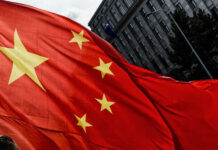 Xi’s Shocking Strategy: Is America Cornered? Close-up of the Chinese flag waving in the wind