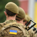 Soldiers with backpacks and Ukrainian flags in formation