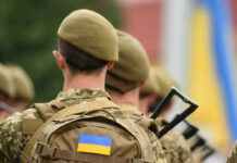 Soldiers with backpacks and Ukrainian flags in formation