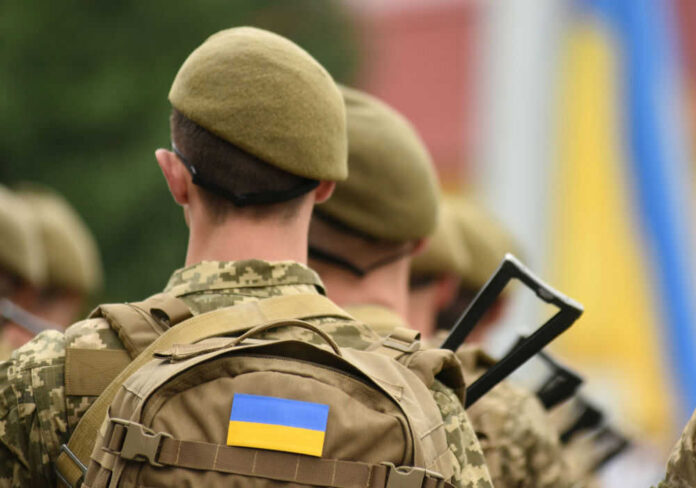 Soldiers with backpacks and Ukrainian flags in formation