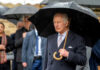 Man holding umbrella in rainy weather with crowd