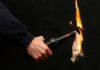 Mobs Torch Homes After Shocking Stabbing Person holding molotov cocktail with flame burning cloth