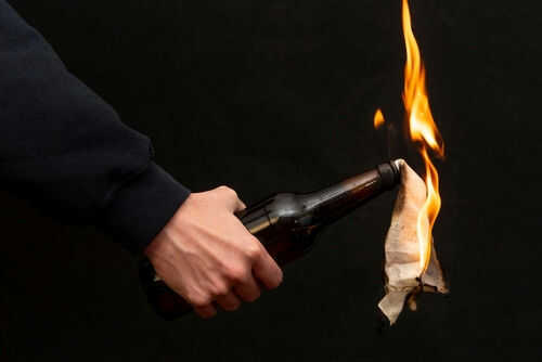 molotov-attack2143490247jpg Person holding molotov cocktail with flame burning cloth