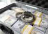 Briefcase with handcuffs and stacks of US dollars