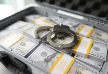 Fraud War Explodes — Billions Yanked Back Briefcase with handcuffs and stacks of US dollars