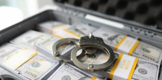 Briefcase with handcuffs and stacks of US dollars