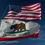 American and California flags waving against a blue sky