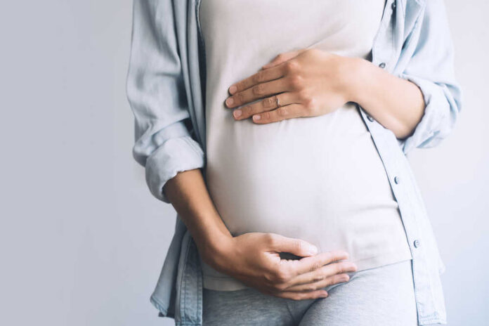 Pregnant,Woman,Holds,Hands,On,Belly,On,White,Background.,Mother Various contraceptive methods on a pink background