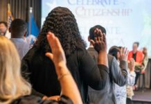Denaturalization Campaign Expands—Fraud Cases Targeted Participants raising their hands during a citizenship oath ceremony