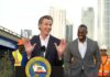 Union Power Play Targets Billionaires’ Fortunes California governor speaking at a construction site with smiling attendees