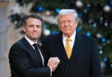 Economic War Plans Quietly Advance Two political leaders shaking hands in front of a decorated backdrop