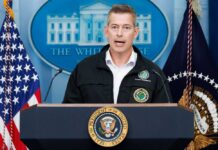 Government official speaking at a press conference in front of the White House