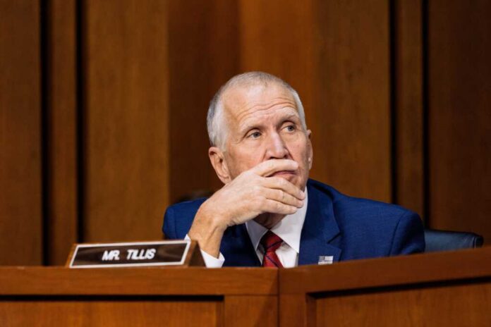 Man in blue suit speaking into a microphone at a meeting
