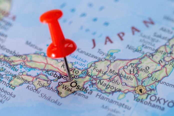 Osaka,A,City,In,Japan,Pinned,On,The,Map. A close-up of a map of Japan with a red pushpin marking Osaka