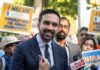 Abolish ICE? NYC Mayor Escalates A man speaking at a rally with supporters holding protest signs