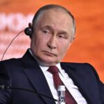 Blackmail Playbook: Moscow Tests Washington man in black overcoat and tie at a formal event