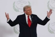 A political figure gesturing with hands during a public appearance