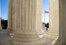 Birthright Shock: Justices Signal Turbulence Marble columns of a neoclassical building with U.S. flag in background